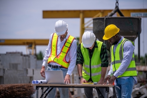 workplace safety culture — supervisor and workers reviewing hazards on a construction job site